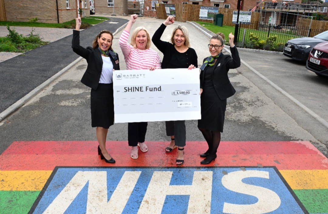 SHINE fundraisers holding a fundraising cheque